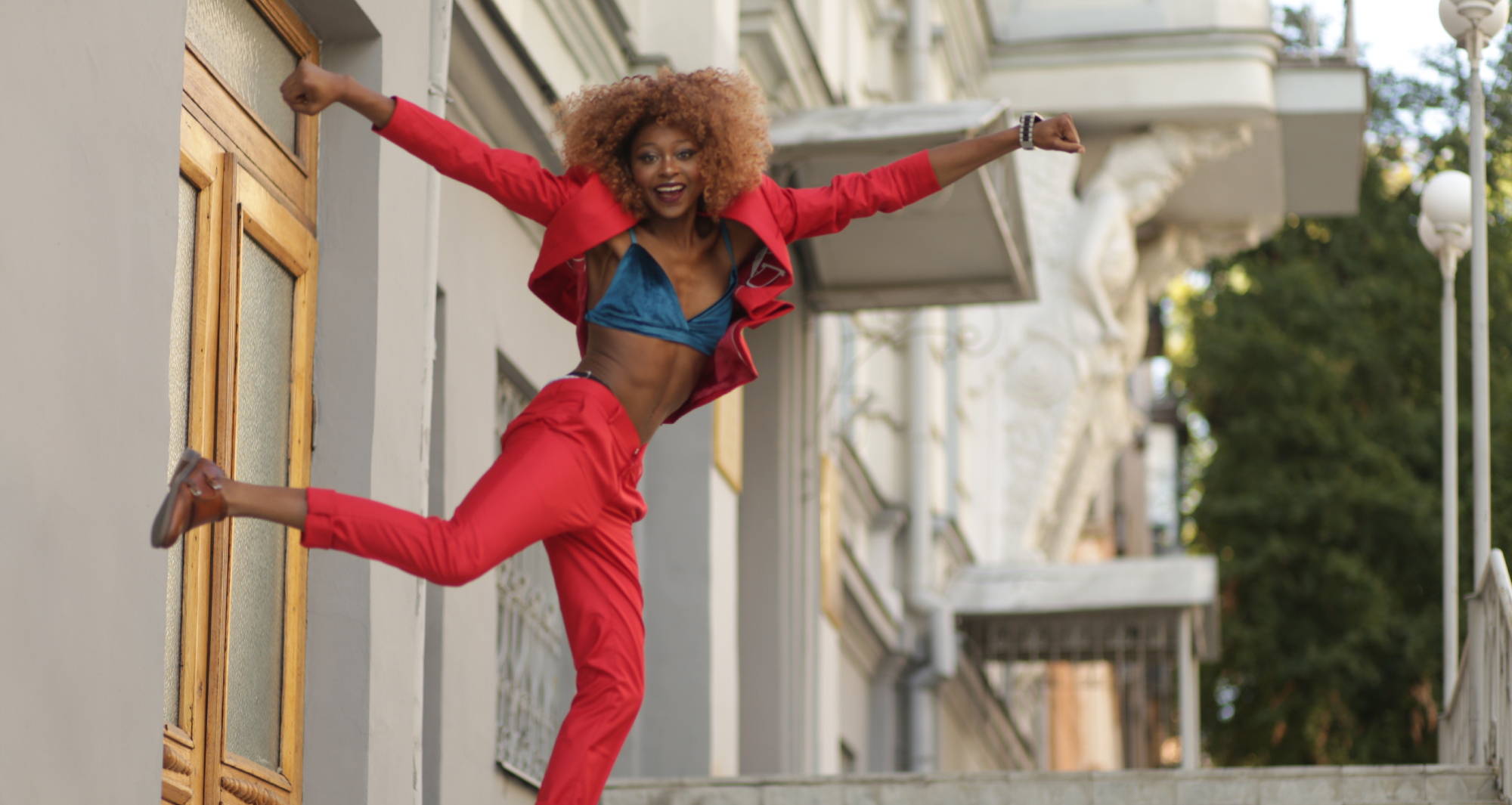 A happy woman with her arms up celebrating how to get rid of camel toe.