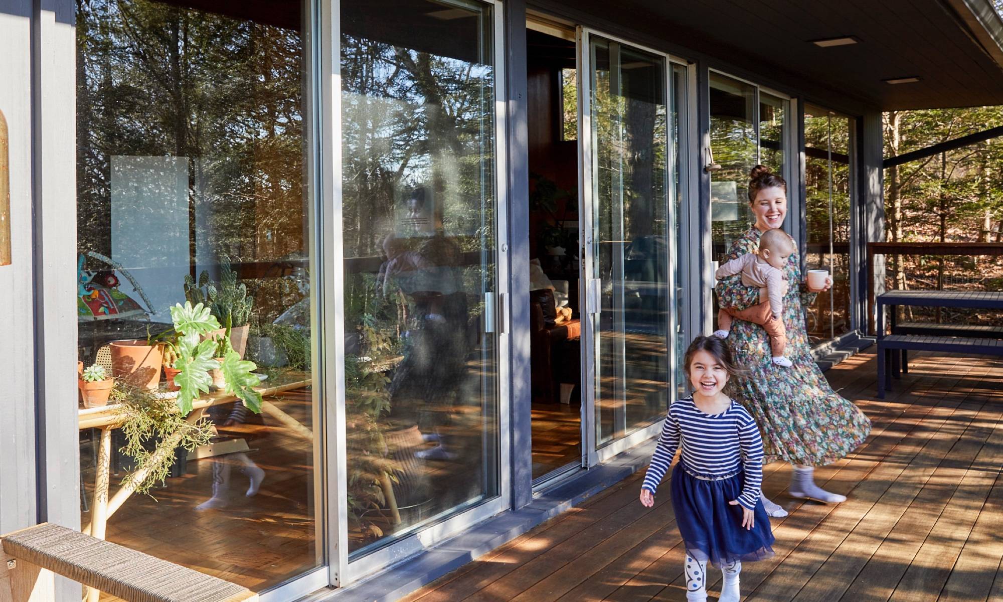 Two kids with mom on porch with sliding glass doors