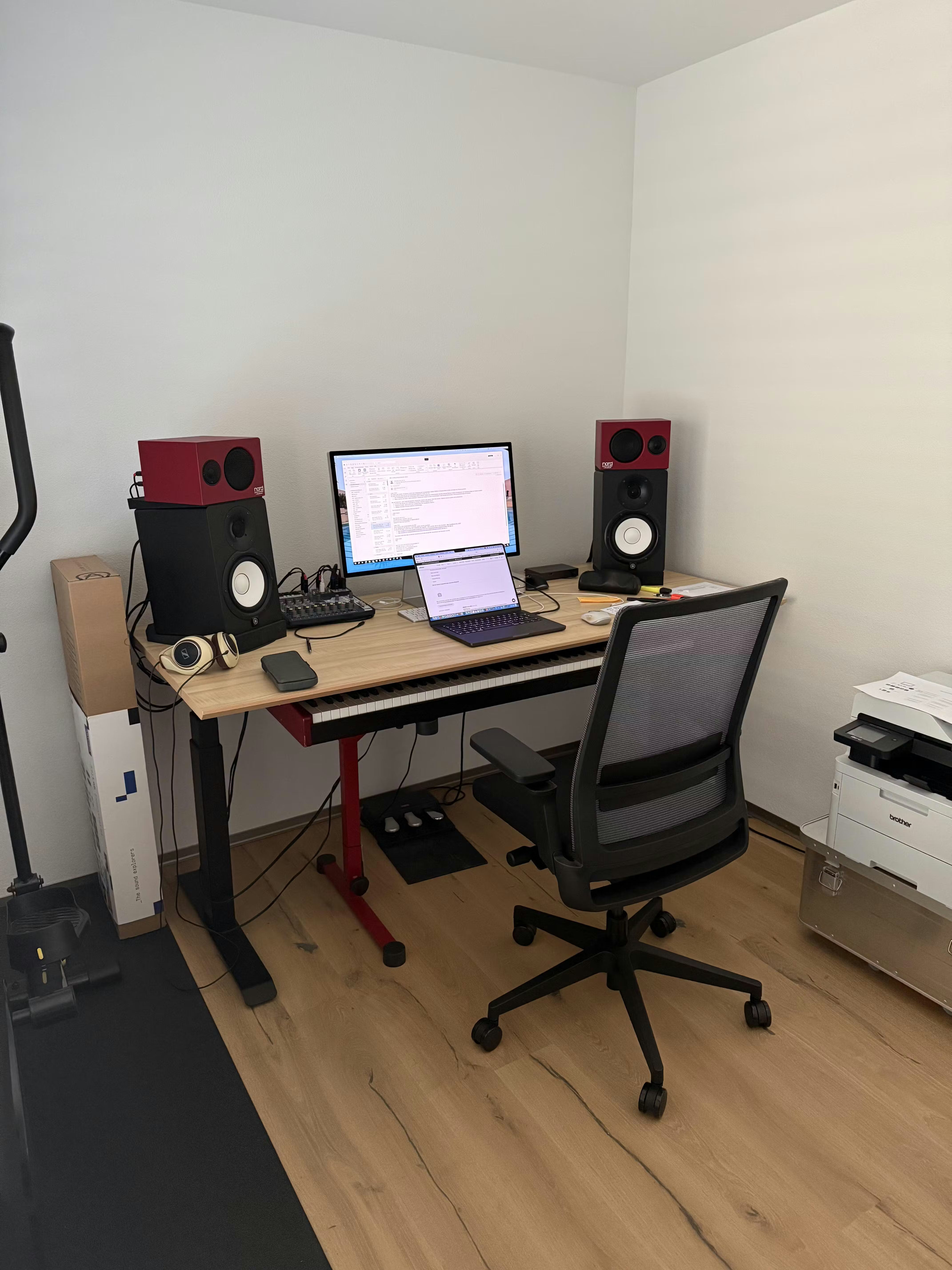 Elektrisch höhenverstellbarer Bürotisch Elevate von ofinto in der Tischplatten-Farbe Natur und Beine aus Schwarz in einem Homeoffice mit Computer, Bildschirm und Tastatur auf dem Tisch