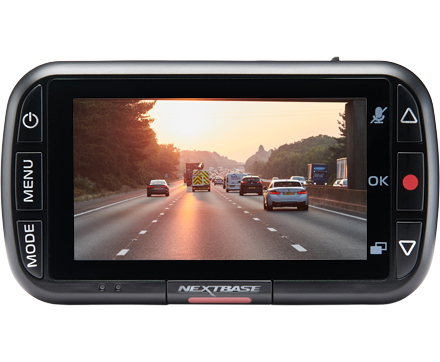 A dashboard camera displaying a highway scene during sunset.