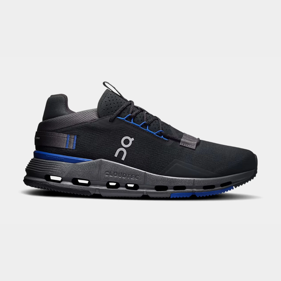 Black athletic shoes with blue accents on a light background.