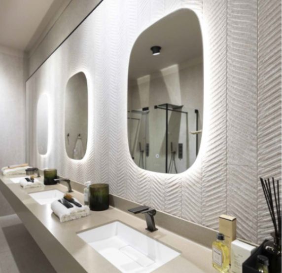 Modern bathroom with illuminated mirrors and sleek sinks.