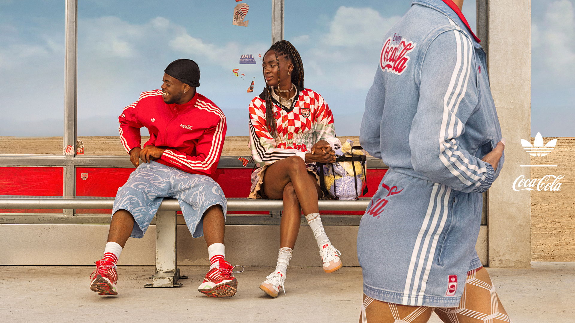 Two people in stylish outfits sitting at a bus stop.