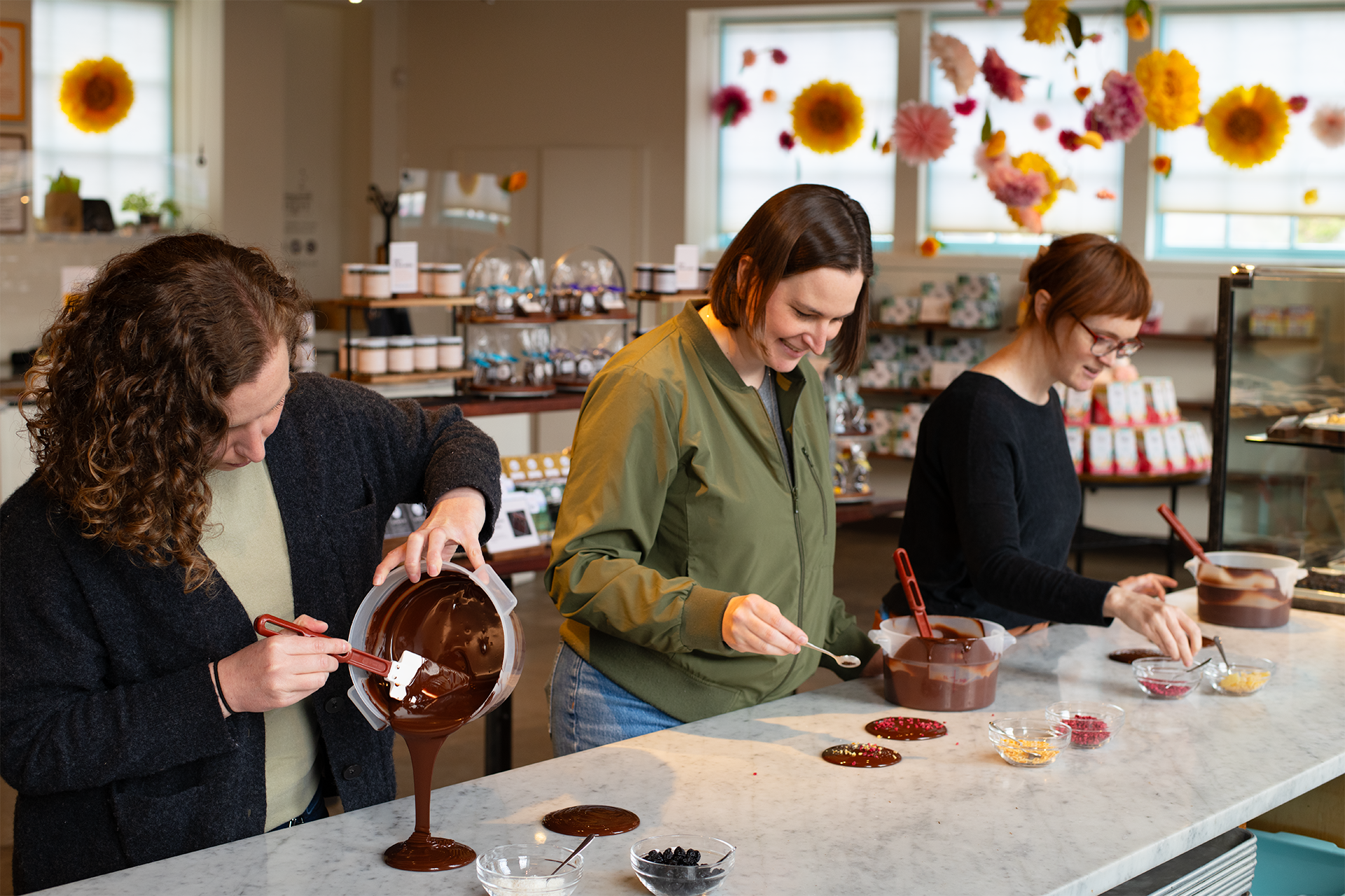 People pouring chocolate during an in-person class.