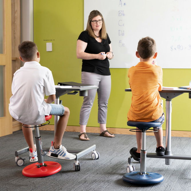 Kids sitting on Kore Design's adjustable wobble chairs