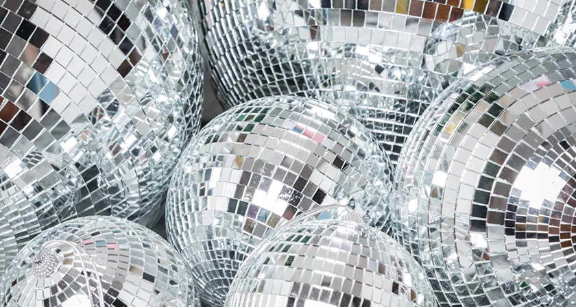 Shimmering silver mirror disco balls in various sizes for retro wedding or dance floor decor.