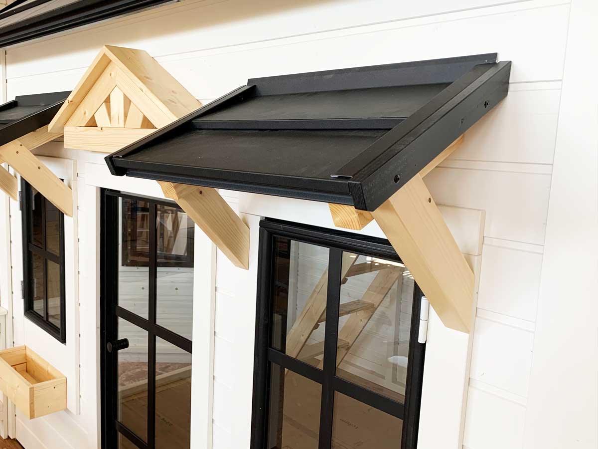 Custom playhouse windows and door on close look in white color with black details by WholeWoodPlayhouses