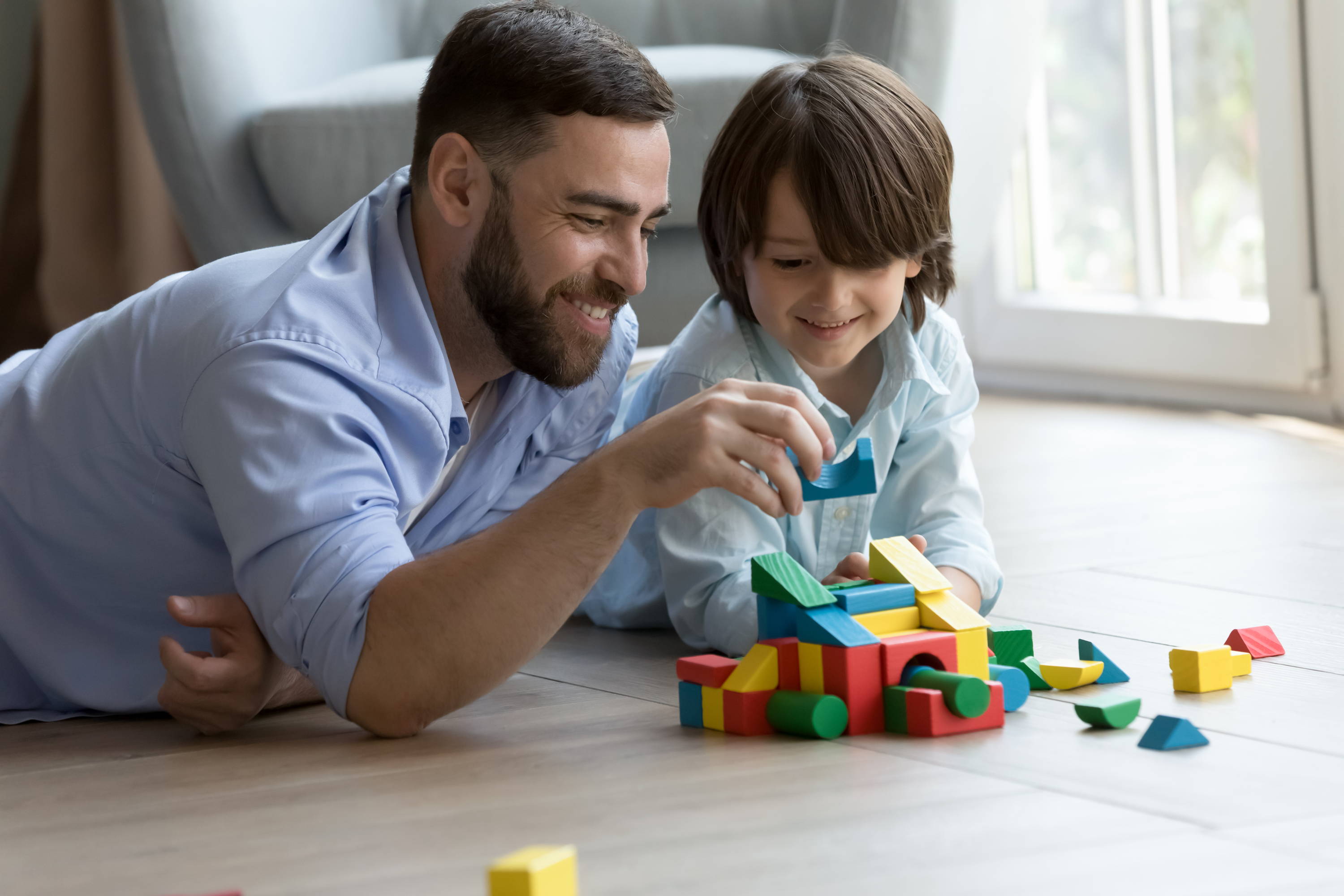 Dad playing with blocks with son on the floor