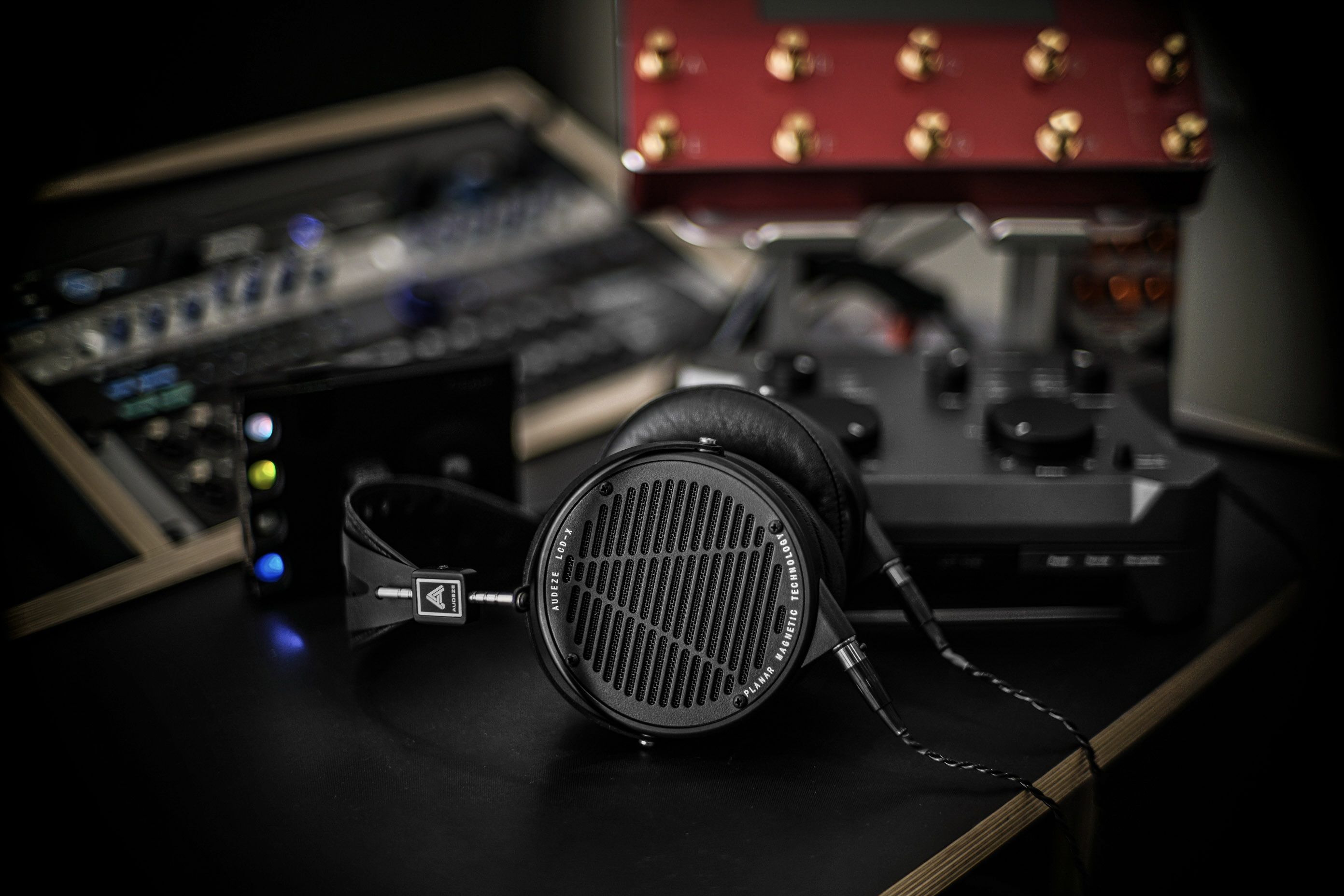 Audeze LCD-X headphones laying on the table in the studio with gear around it 