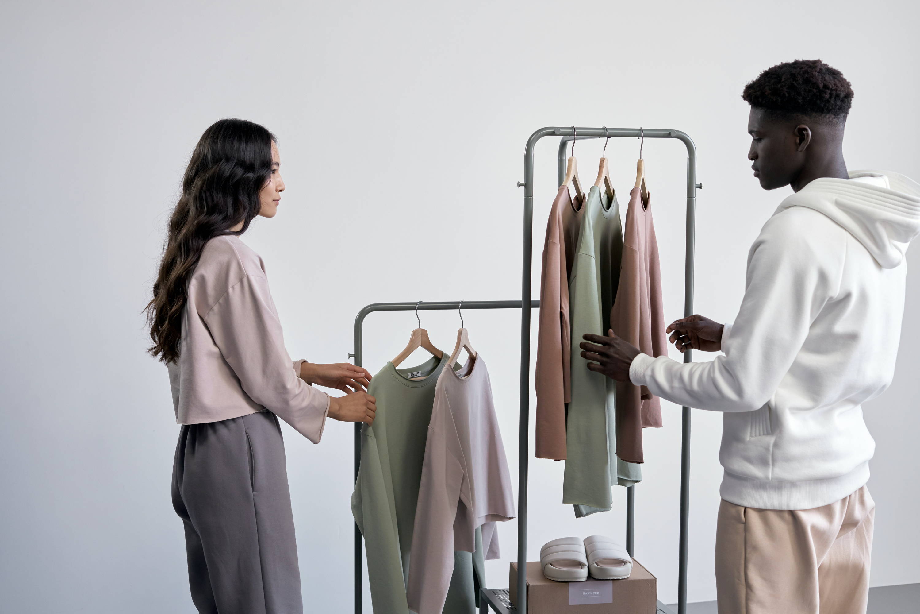 man and woman looking through a small rack of clothes