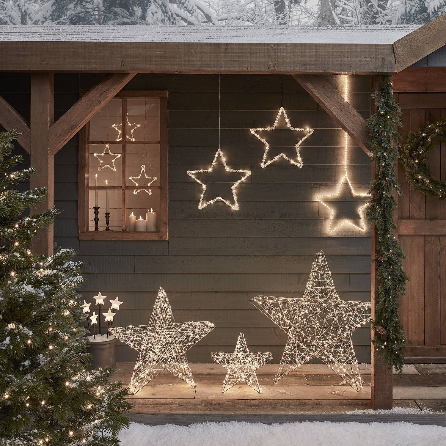 A winter wonderland setting with star lights placed around a cottage.