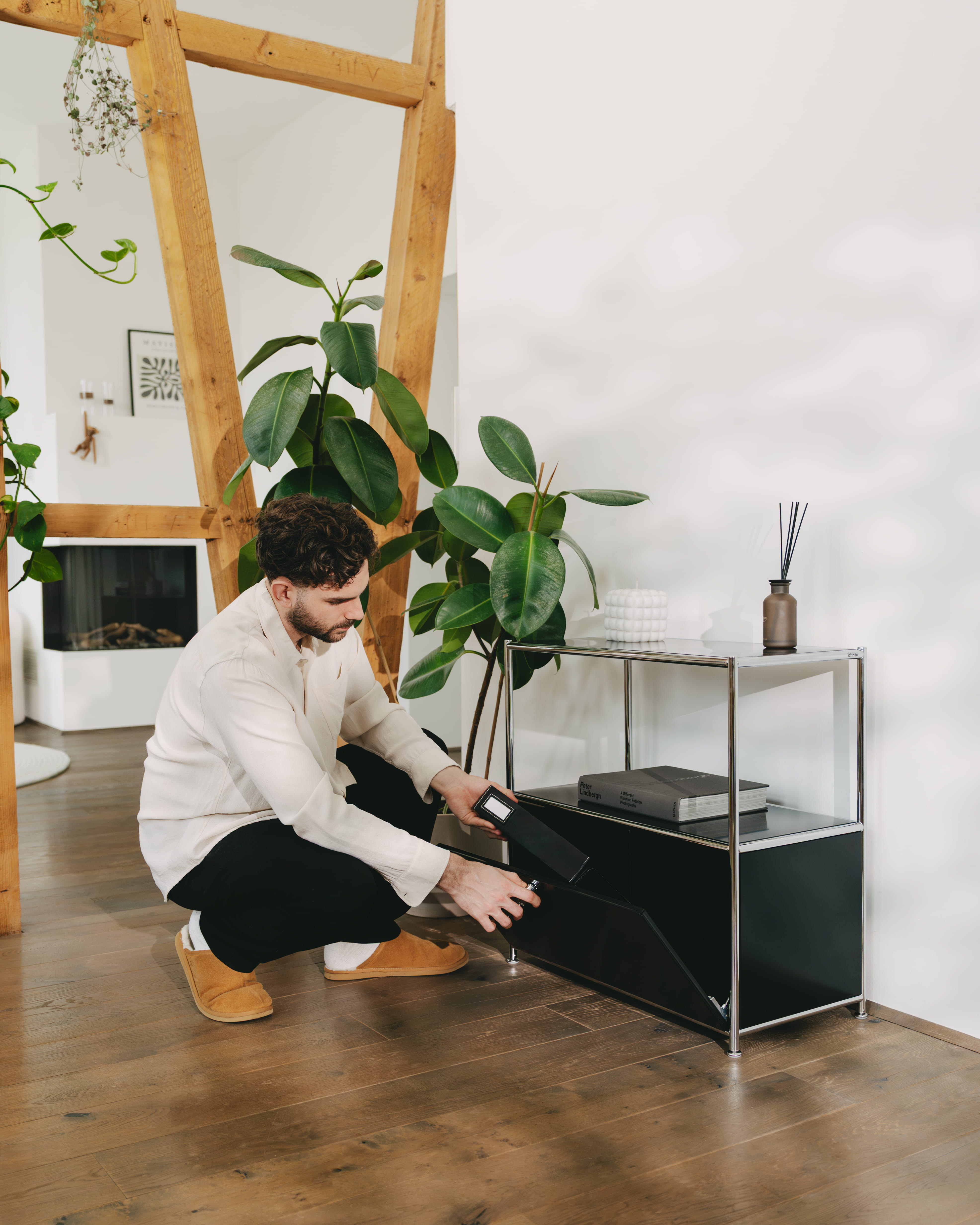 A man organizes his living room with an ofinto Cubox chest of drawers