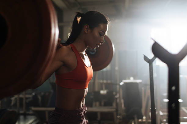 woman lifting heavy weights, woman concentrating