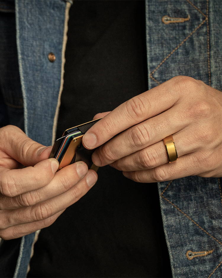man checking out cards while wearing a Ridge 24K Gold 8MM Beveled Ring on his finger