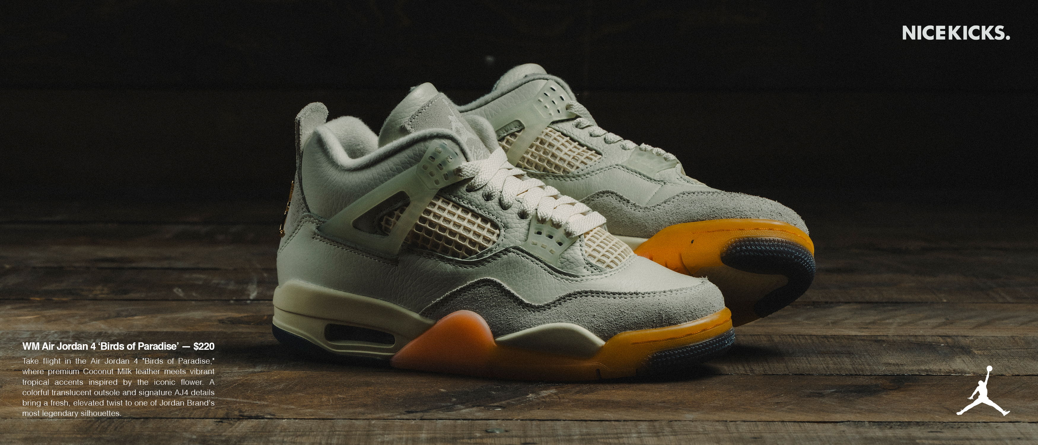 A pair of gray and orange Air Jordan 4 sneakers on a wooden surface.