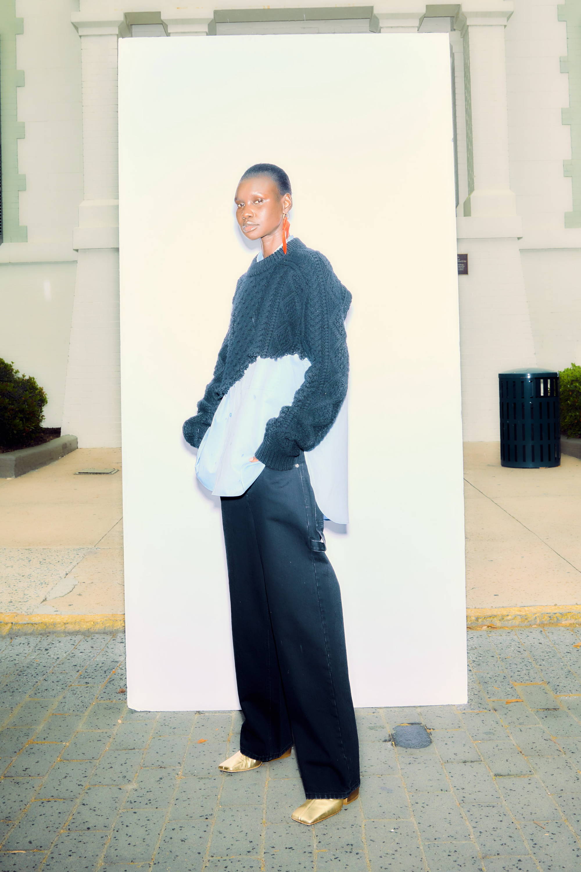 Person wearing a unique outfit, standing in front of a blank backdrop.