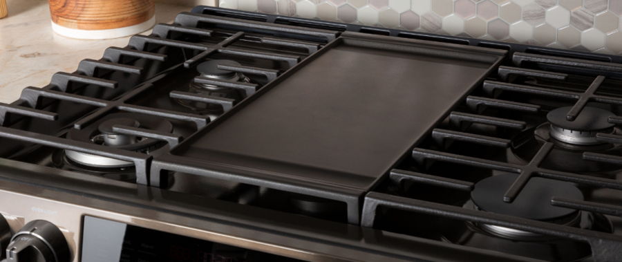 Black gas stove grates with a flat cooking surface in the center.