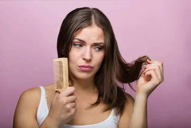 Girl looking concerned at her split ends