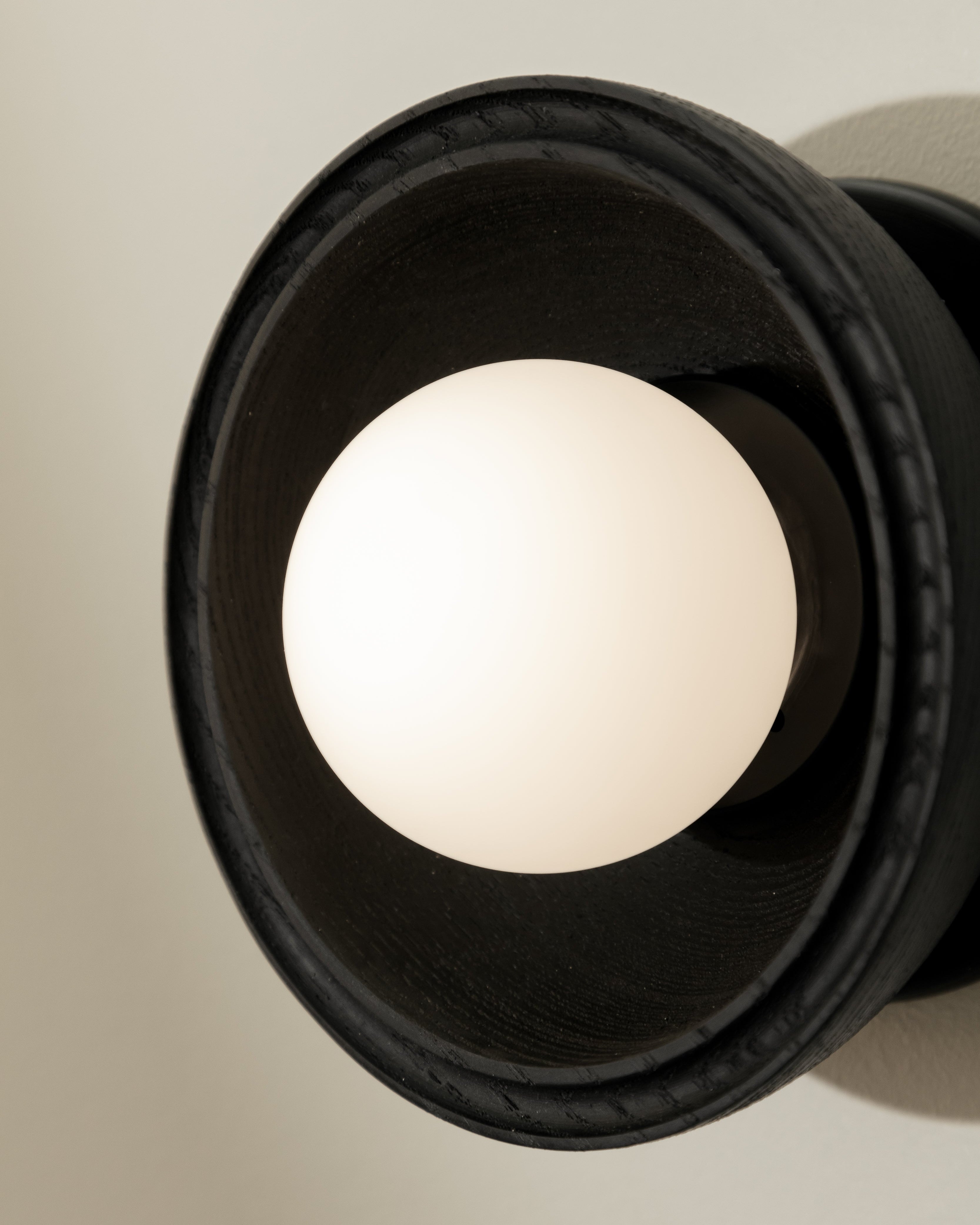 Close-up of a light fixture with a beige bulb on a neutral background