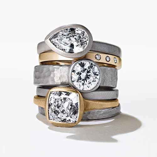 Various rings stacked on top of ano another with lab grown diamonds by MiaDonna