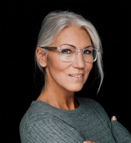 Woman with grey hair wearing Grace clear eyeglasses