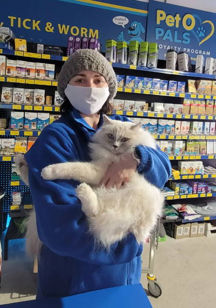 A woman holding a cat inside a pet store