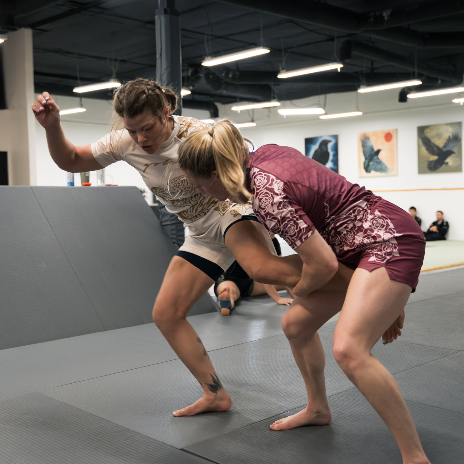 Two athletes sparring in a martial arts training facility.