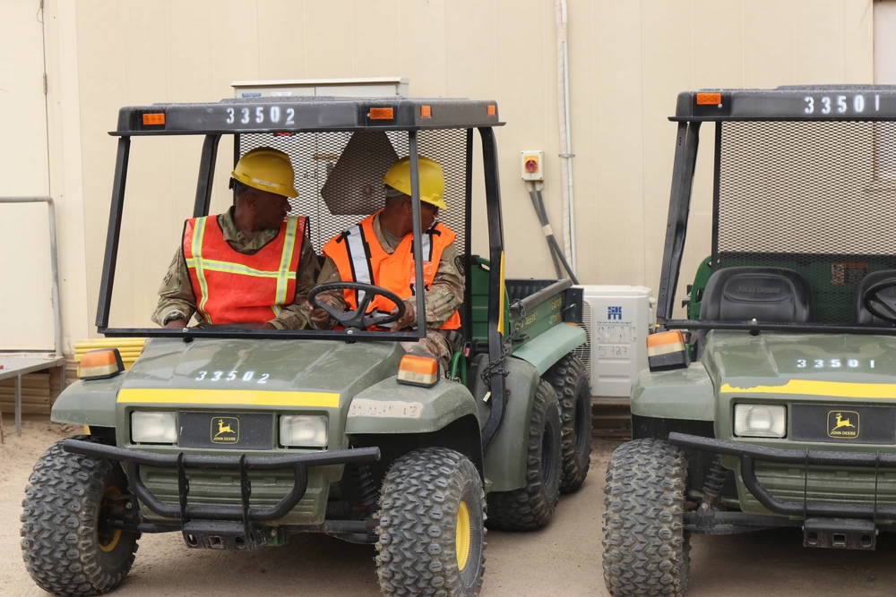 Private Tyreek Taylor, 335th Signal Command (Theater) (Provisional) Multimedia Illustrator, receives coaching from MSG Timmie Crosby, 335th Signal Command (T) (P) G4 NCOIC, on driving the John Deere Gator at Camp Arifjan, Kuwait, 15 January 2019. (U.S. Army photos by Capt. Brandon Fambro)