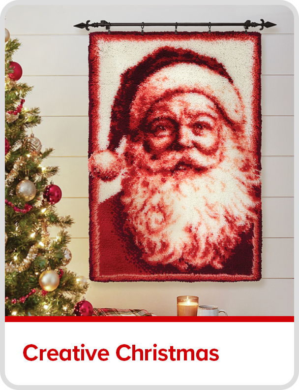 Santa Claus portrait hanging above a Christmas tree and candle. Creative Christmas