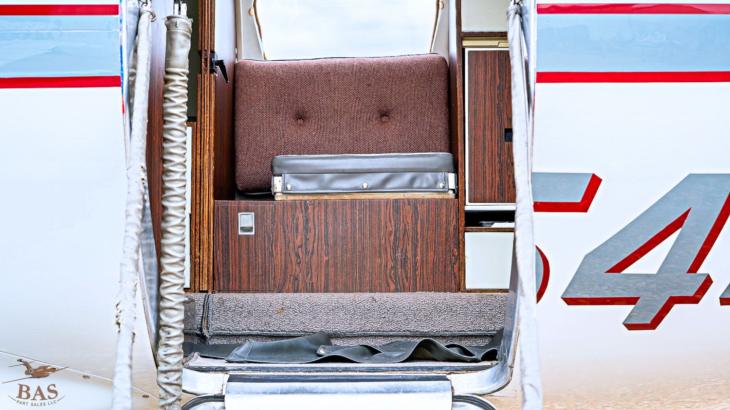 Interior view of a private jet with seating and wood paneling.