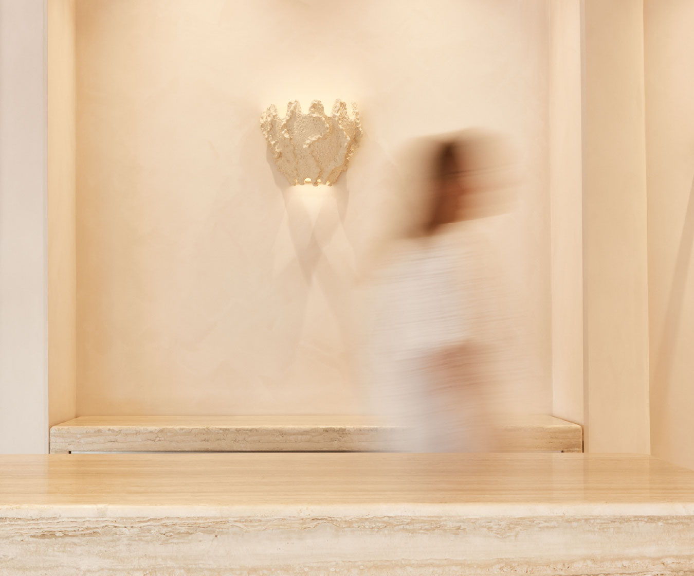 Woman walking in store with shell on wall