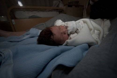 Newborn Baby On A Bed
