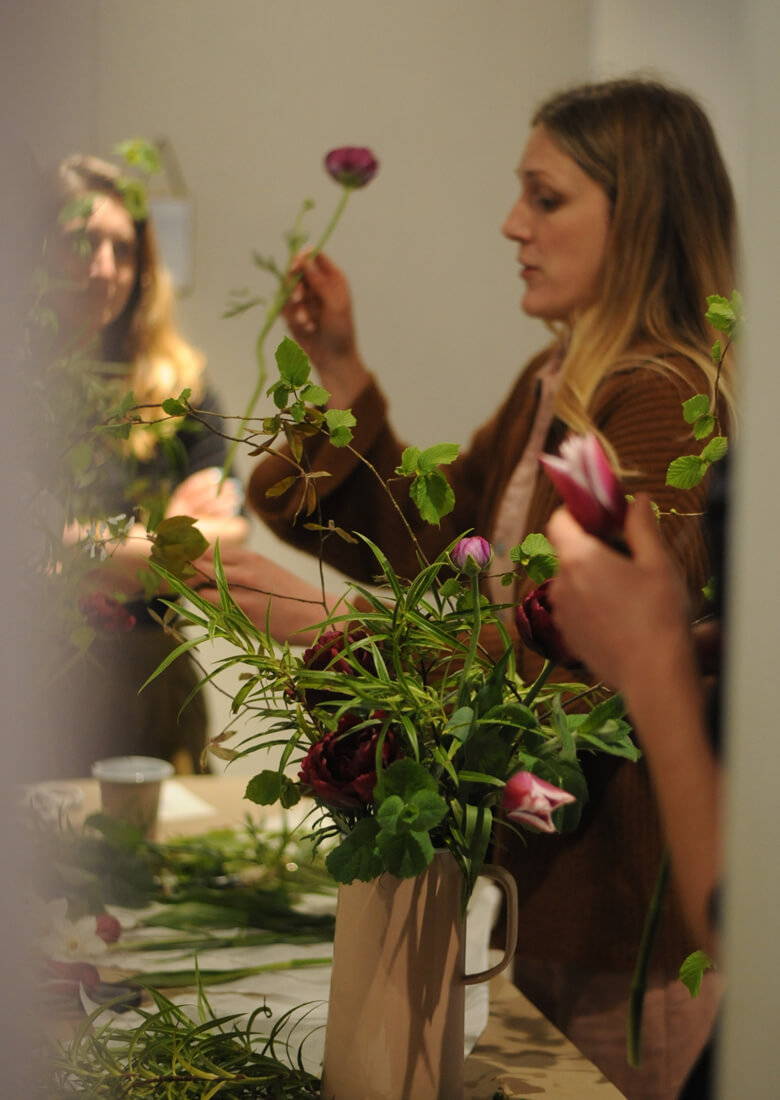 Milli showing how to place a ranunculus in a floral display.