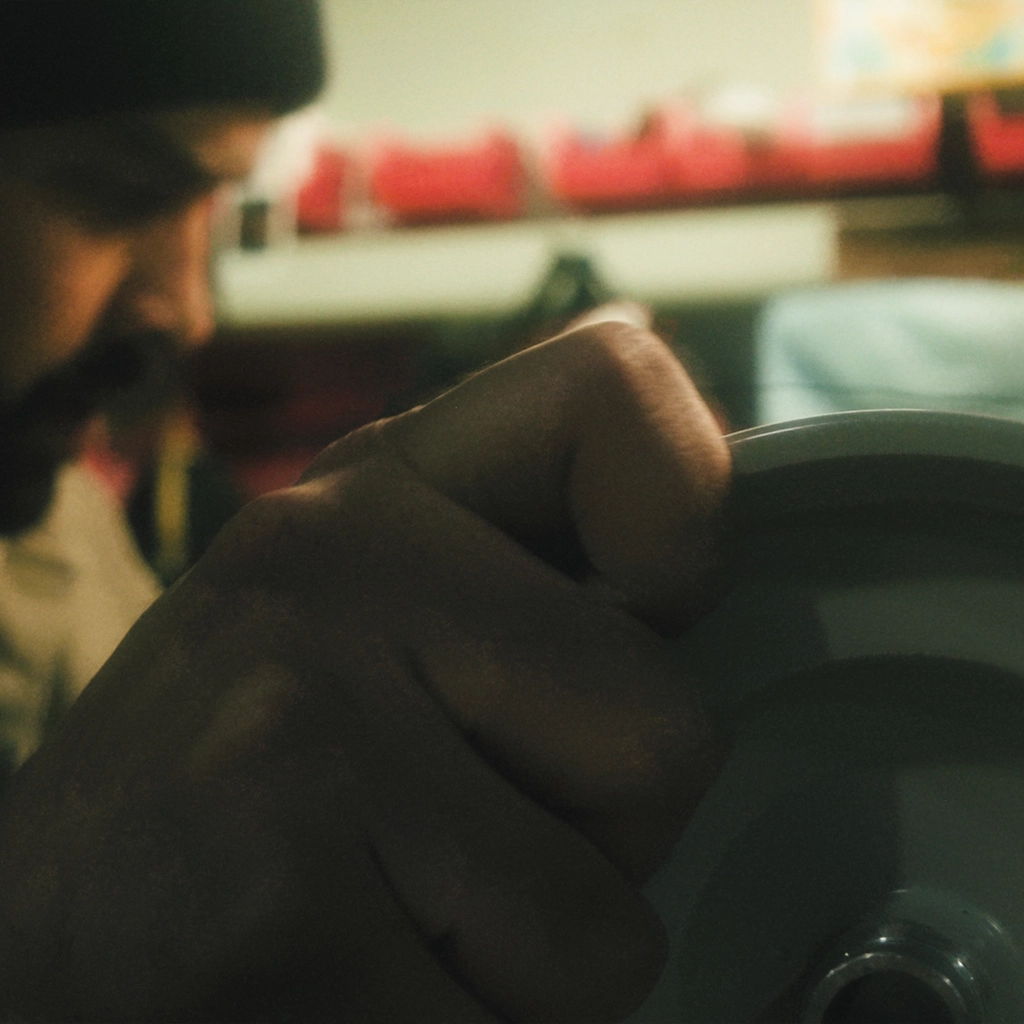 A person gripping a round object, with a blurred background.