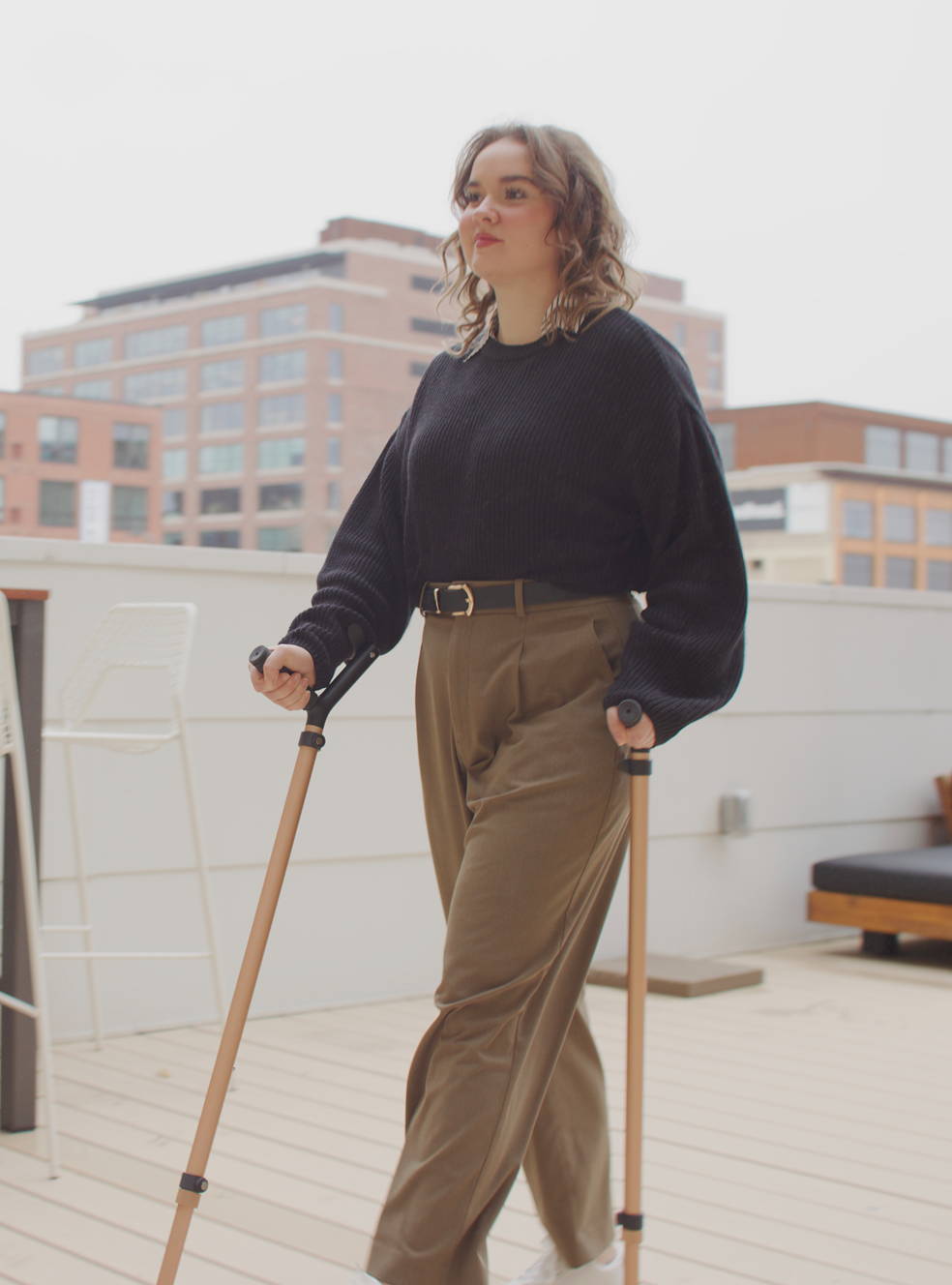 Young woman walking outdoors using a pair of Y-Canes, demonstrating upright posture