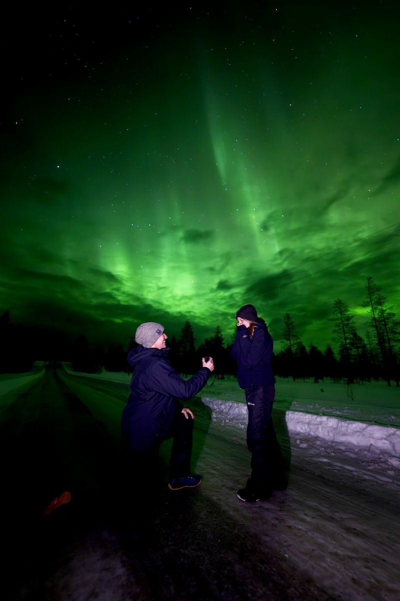 couple getting engaged with northern lights in background