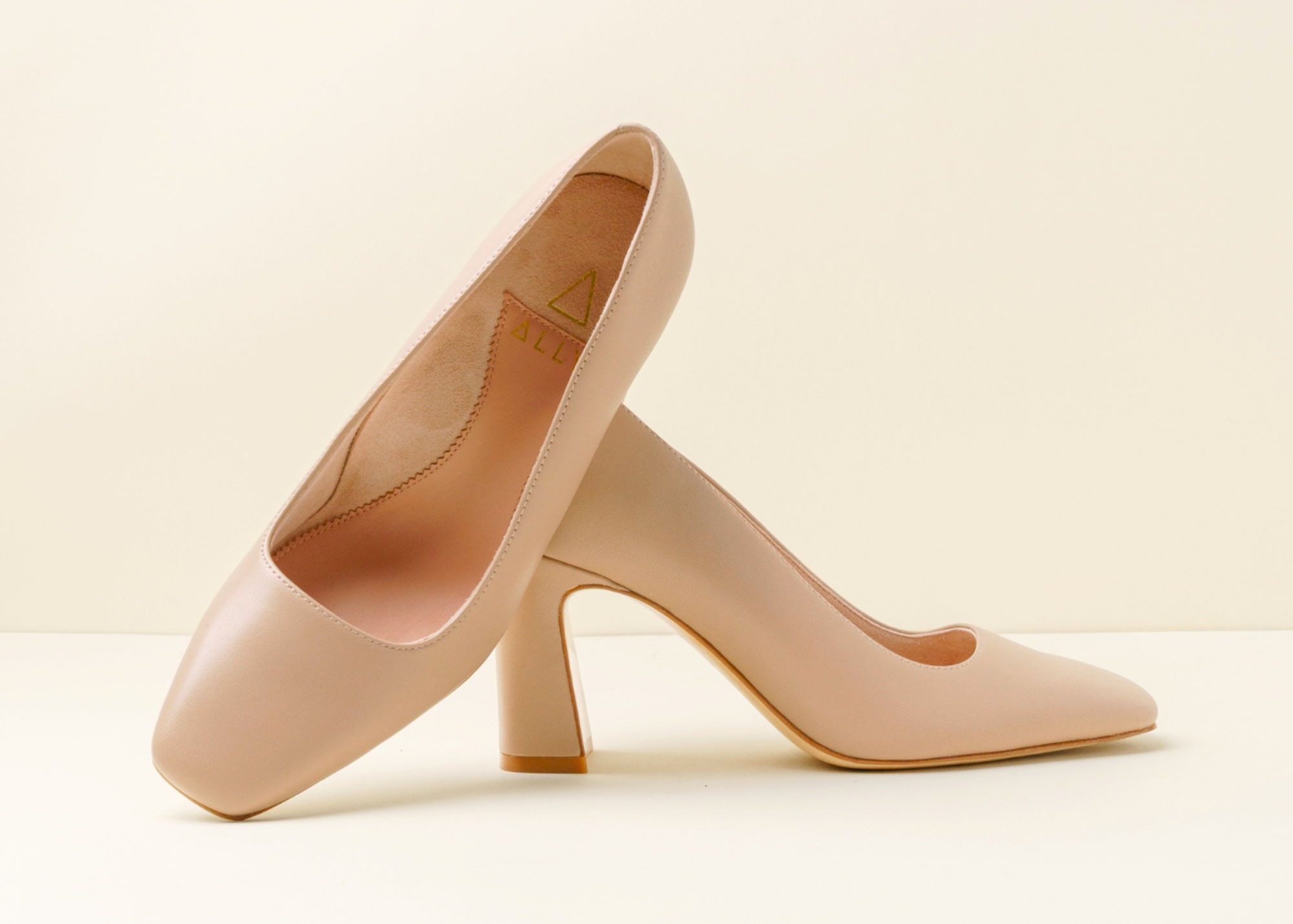 Beige high heel shoe with a chunky heel, side view.