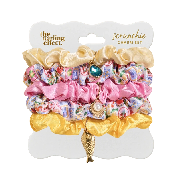 Colorful hair scrunchies with charms on a display card.