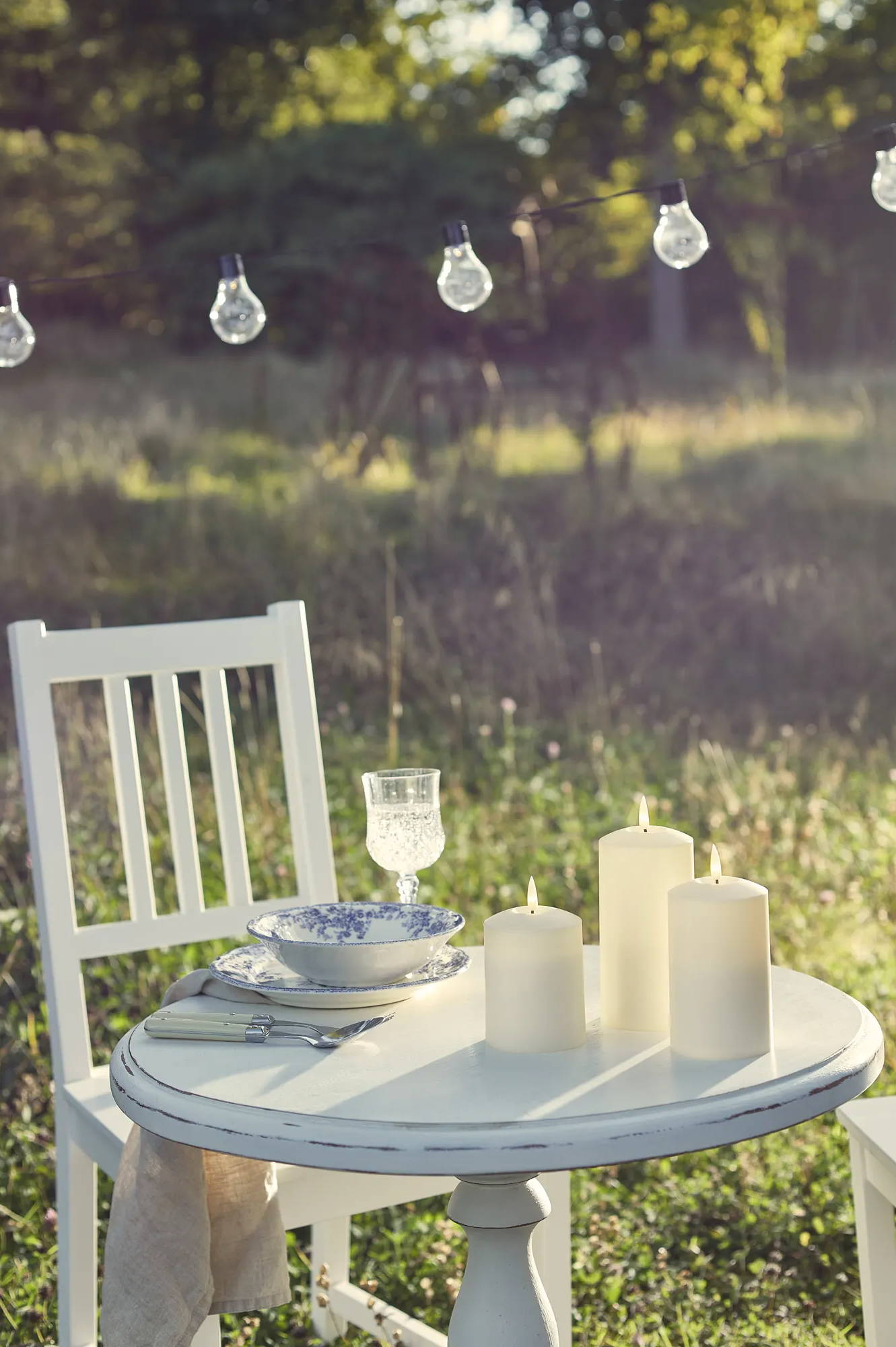 Meadow dining table arrangement with TruGlow candles and festoons hung above table
