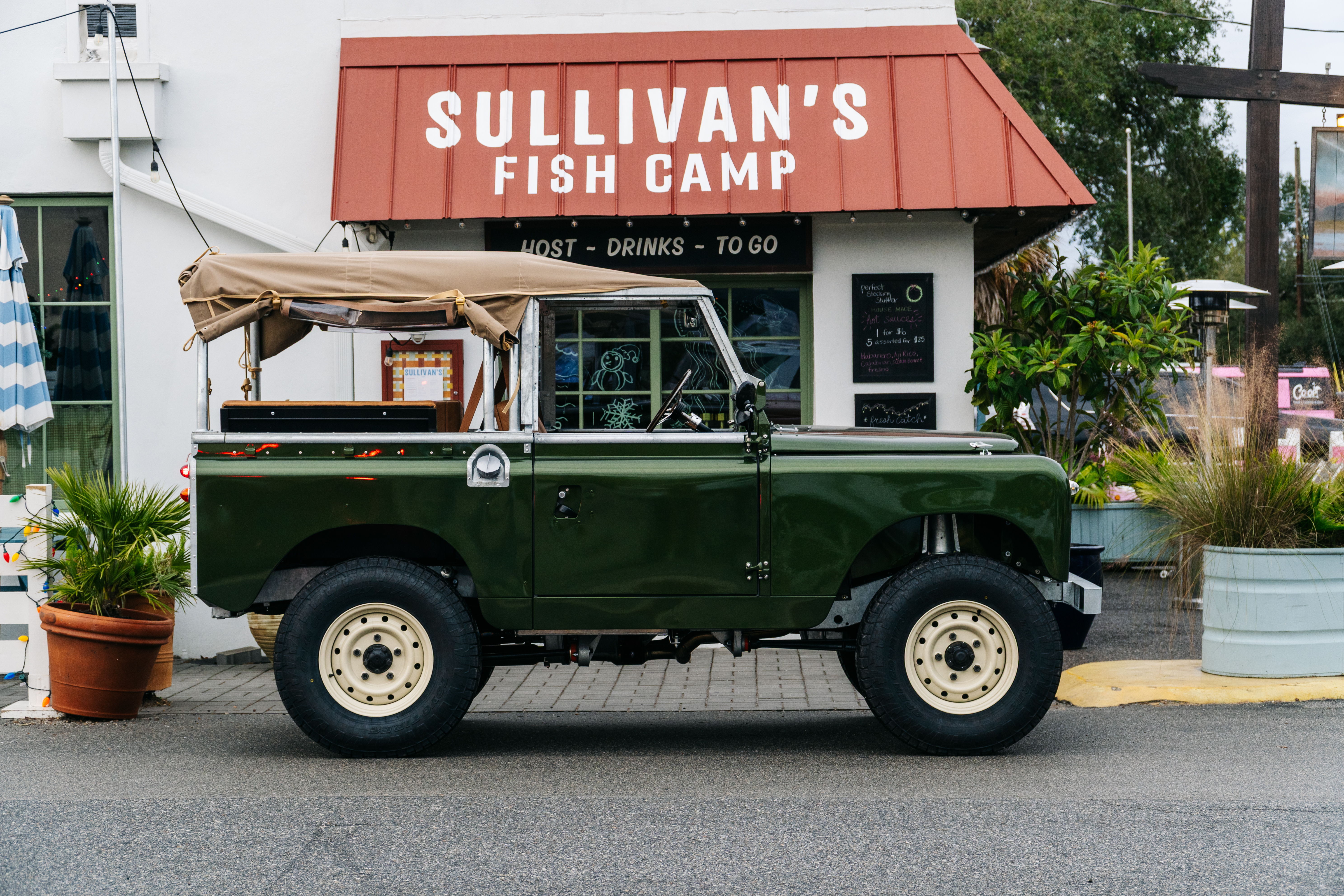 A green vintage jeep parked outside Sullivan's Fish Camp restaurant.