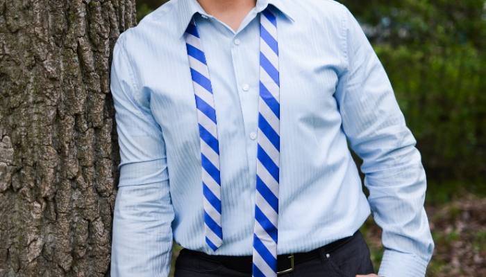 Man wearing an untied blue and silver striped tie