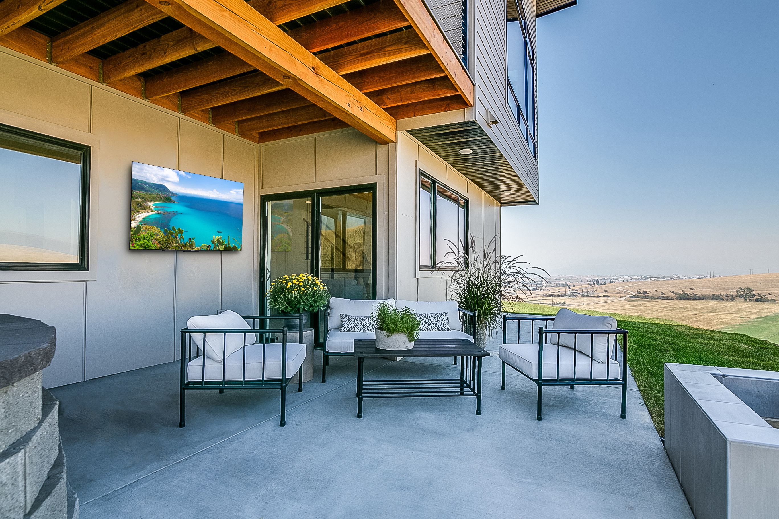Modern patio area with seating and a view.