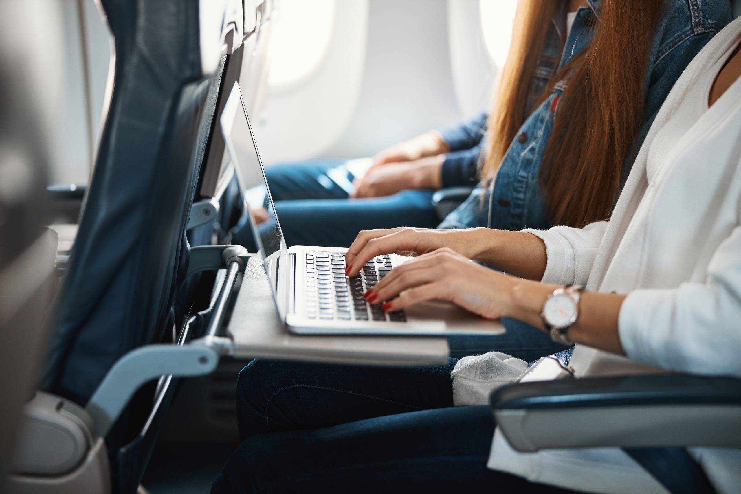 Žena používající notebook na palubě letadla