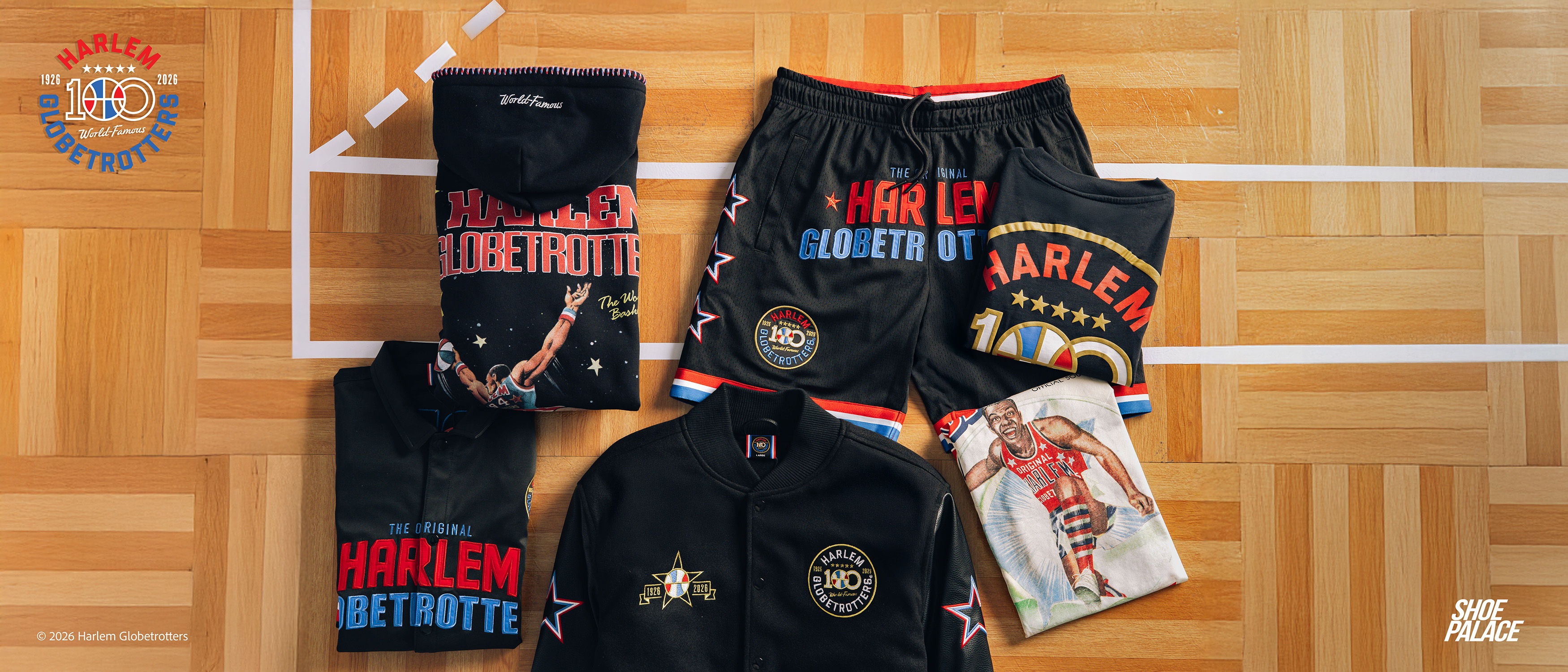 Basketball apparel including shorts, jerseys, and a magazine on a wooden floor.