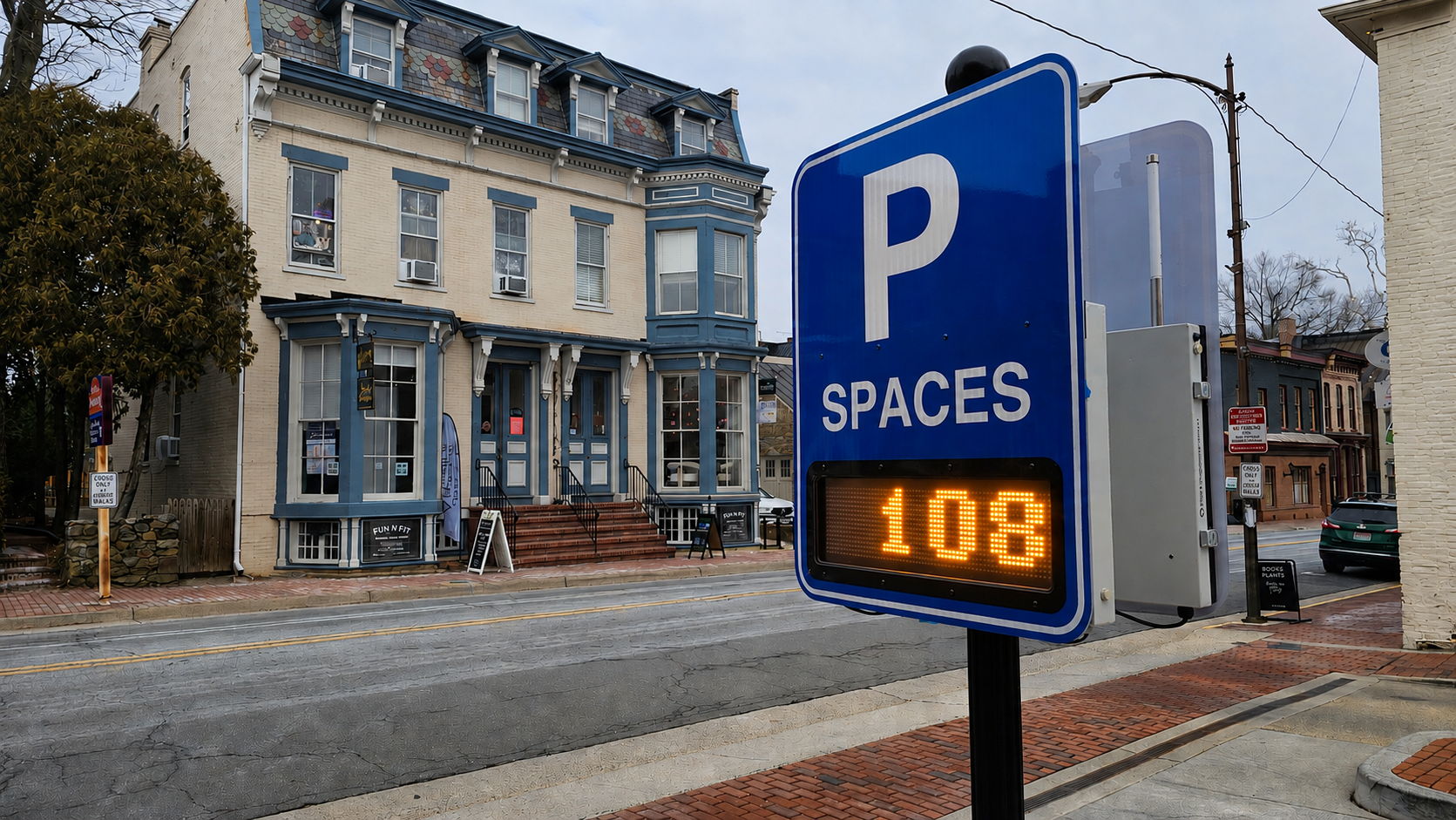 Driver checking a space-available sign at a parking garage entrance