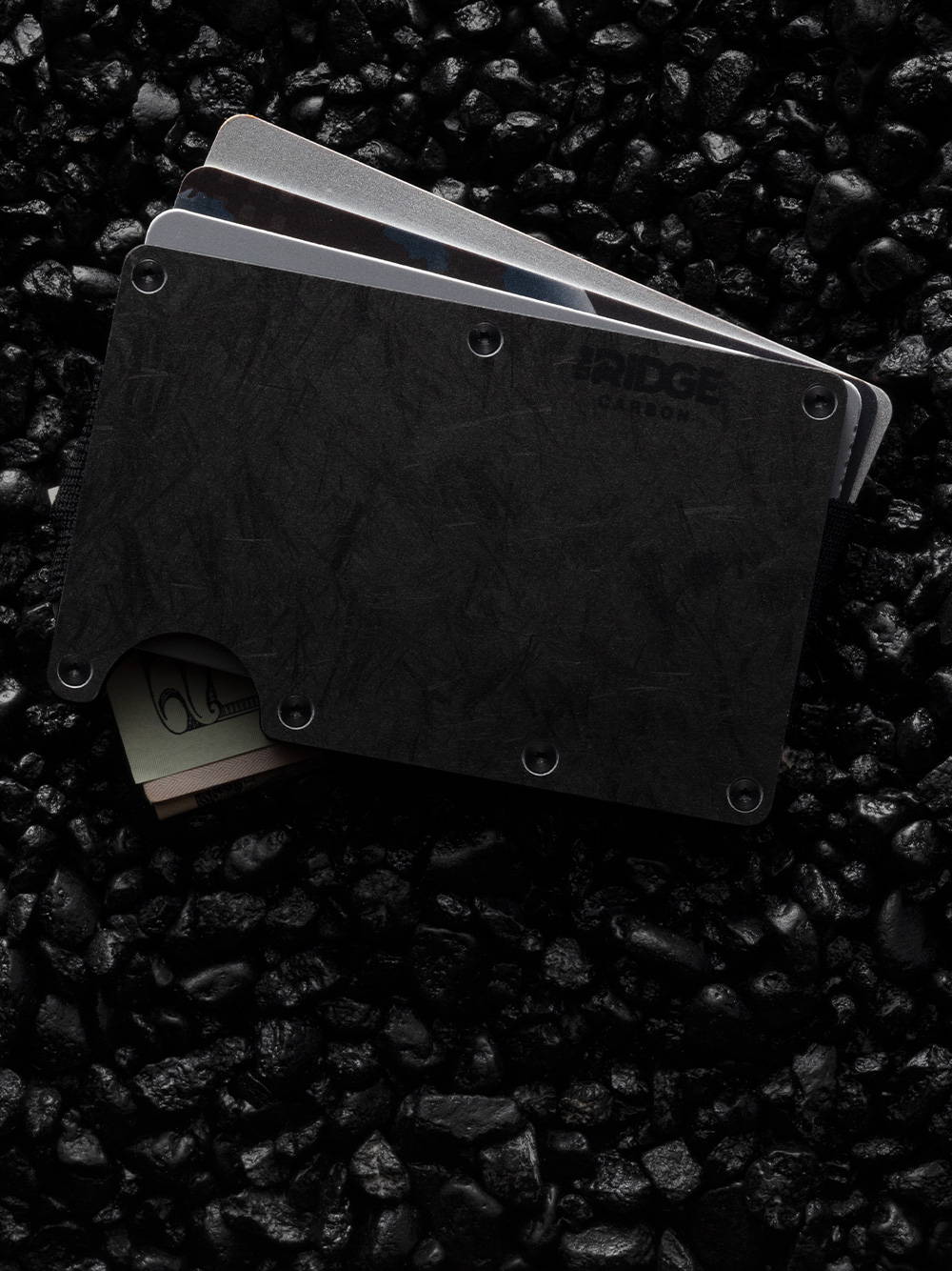 Forged Carbon Ridge wallet with pulled out cards on top of carbon deposits