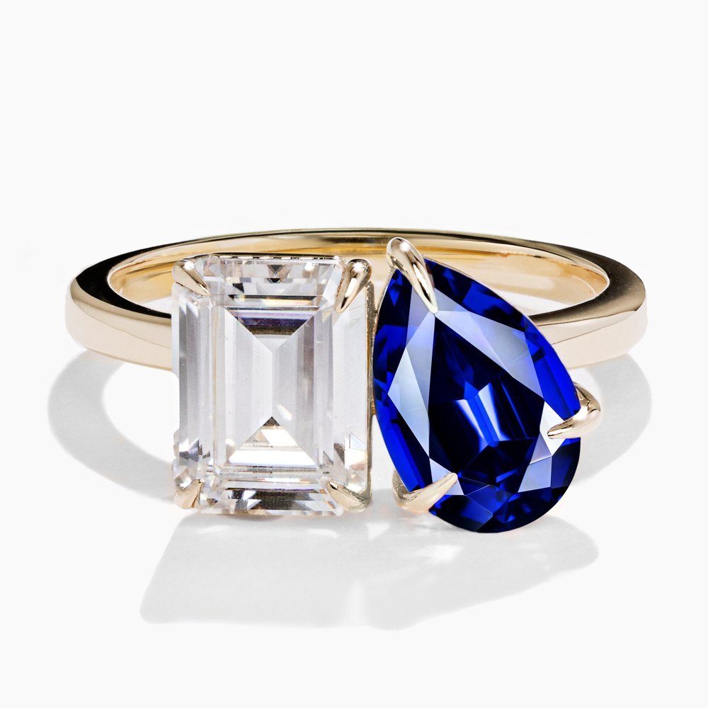 toi et moi engagement ring featuring an emerald cut lab grown diamond and. a pear cut lab grown sapphire gemstone by MiaDonna