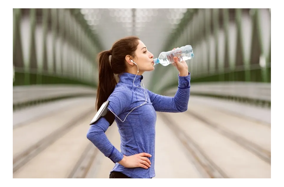 woman stopped on run drinking water