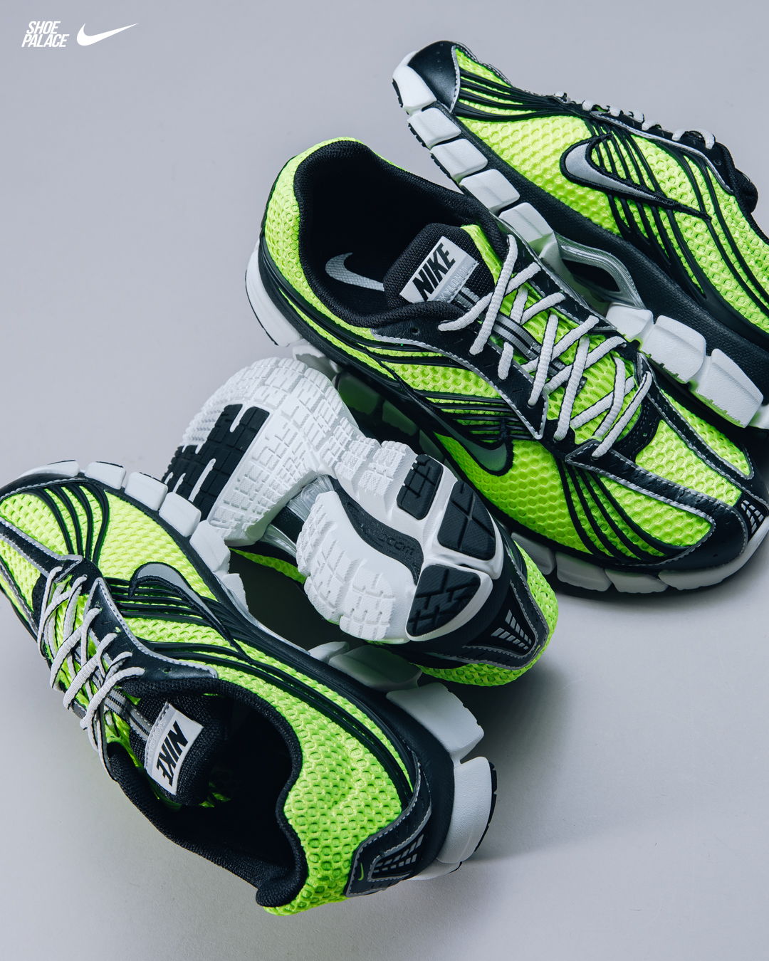 Nike sneakers in vibrant yellow and black, arranged aesthetically on a gray background.