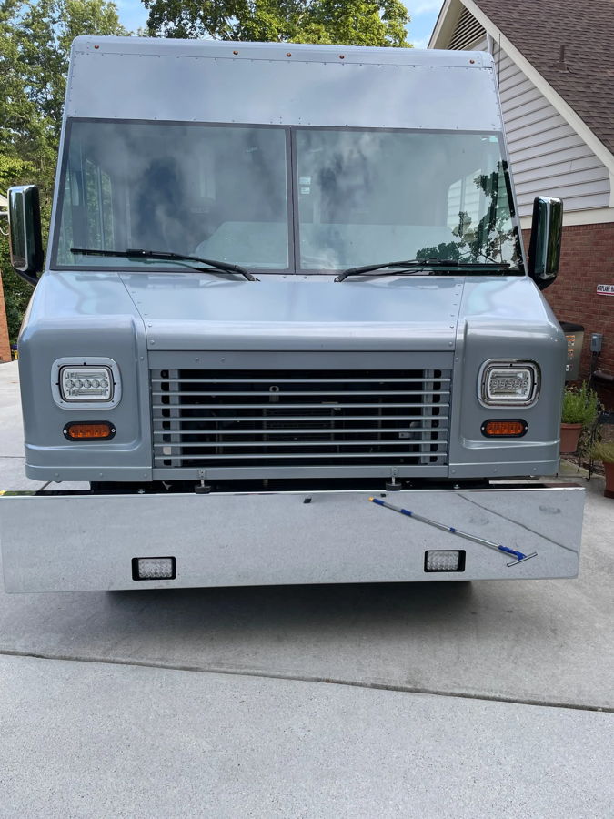 Front head-on custom grey step van with LED headlights and polished chrome bumper photo 2